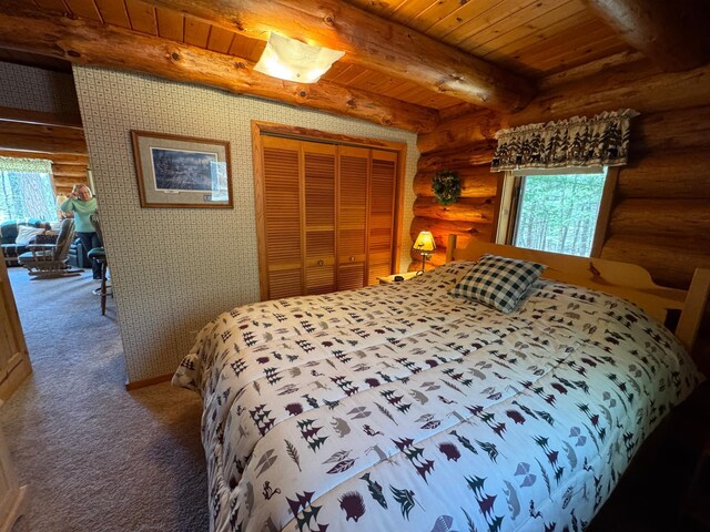 bedroom with carpet floors, rustic walls, multiple windows, and wood ceiling