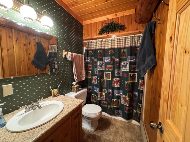 bathroom with wooden walls, vanity, toilet, and curtained shower