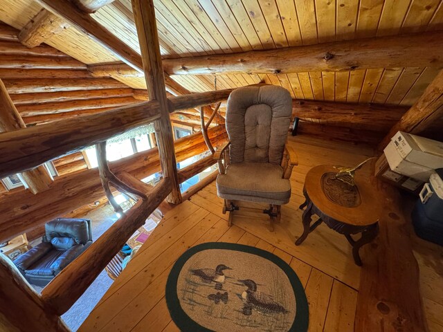 sitting room with wood-type flooring, log walls, wood ceiling, and beamed ceiling