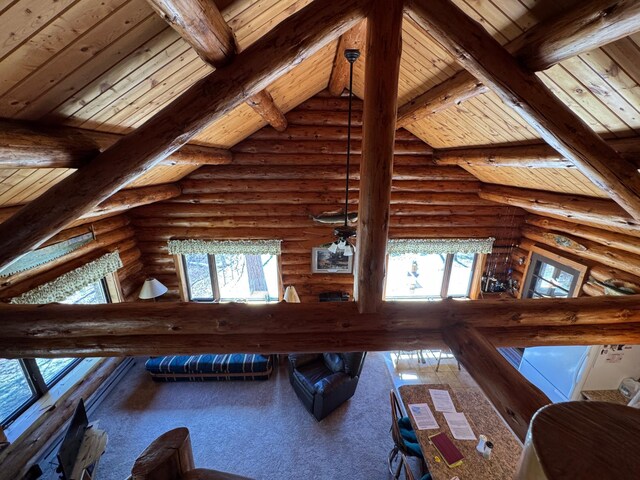living room featuring lofted ceiling with beams, log walls, and wooden ceiling
