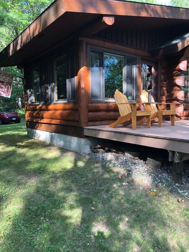view of side of home featuring a lawn, crawl space, and a deck