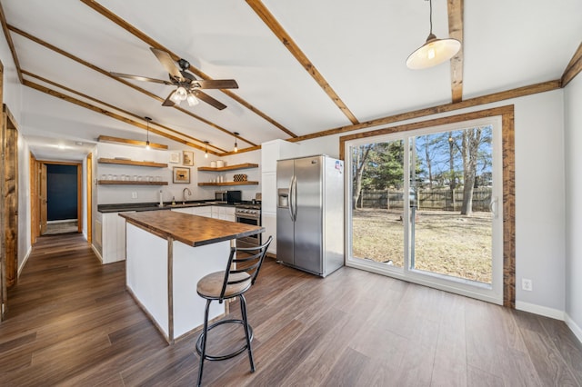 kitchen with ceiling fan, wooden counters, appliances with stainless steel finishes, open shelves, and vaulted ceiling with beams