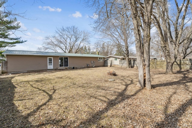 rear view of property featuring a fenced backyard and metal roof