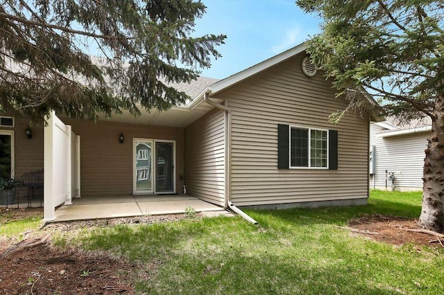 back of property featuring a patio and a yard