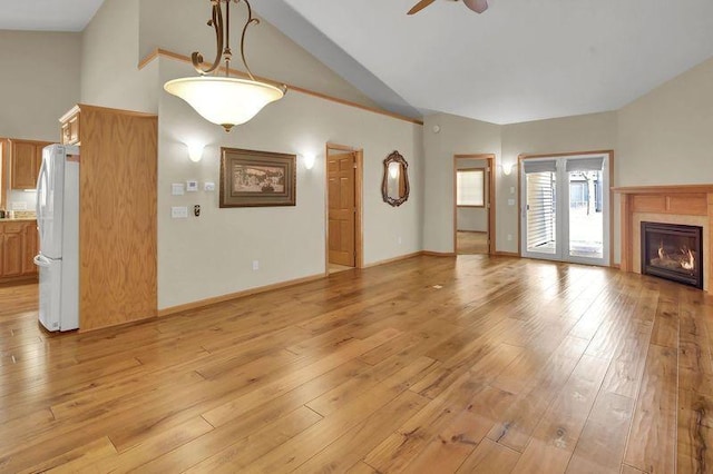 unfurnished living room with light wood-style floors, ceiling fan, and a glass covered fireplace