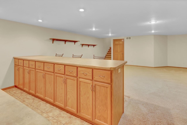 kitchen featuring recessed lighting, a peninsula, light countertops, and baseboards