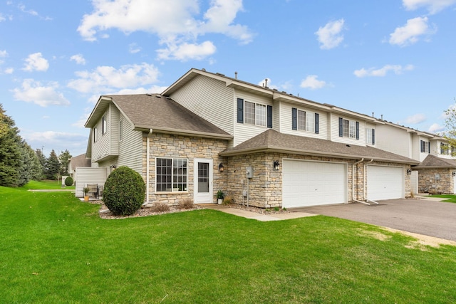 traditional-style home with a shingled roof, an attached garage, a front lawn, aphalt driveway, and stone siding