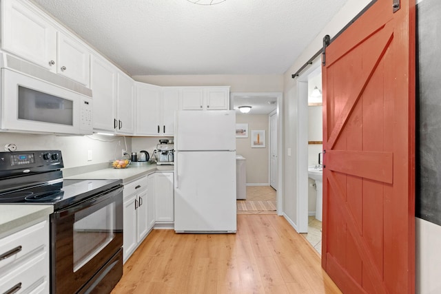 kitchen with white appliances, light countertops, white cabinetry, and light wood-type flooring