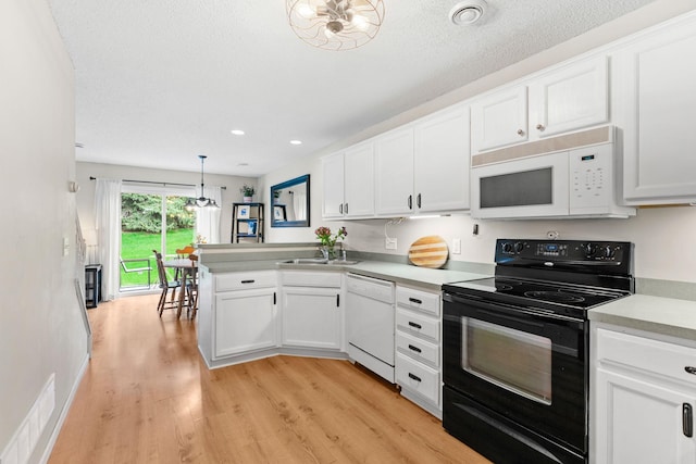 kitchen with white appliances, light countertops, light wood-style flooring, a peninsula, and white cabinetry