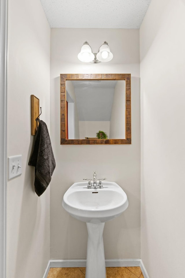 bathroom with baseboards and tile patterned floors