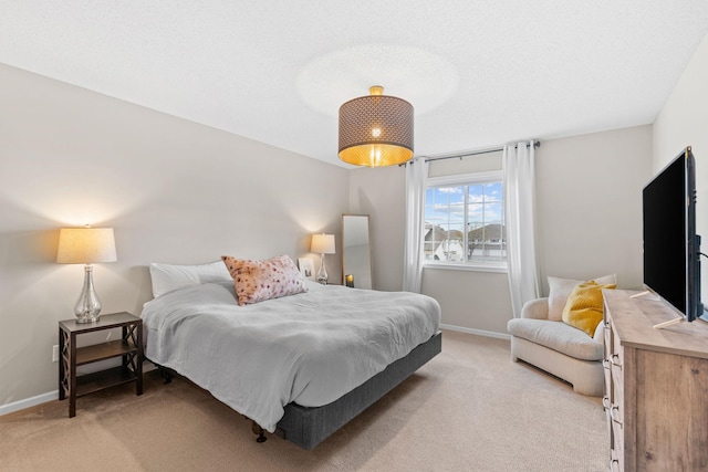 bedroom with baseboards and light carpet