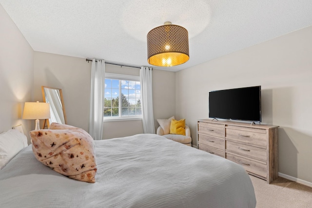 bedroom with baseboards and light colored carpet