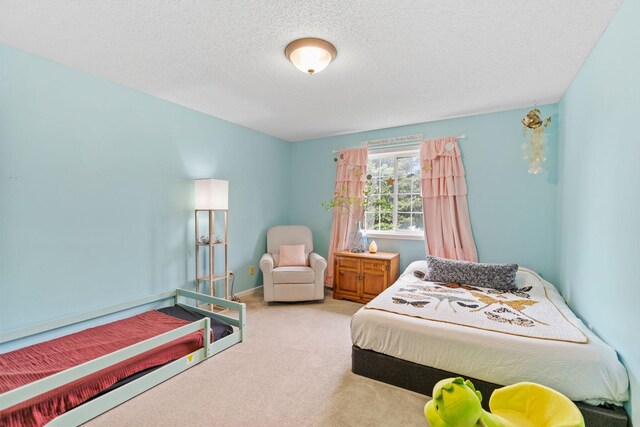 bedroom with carpet floors and a textured ceiling
