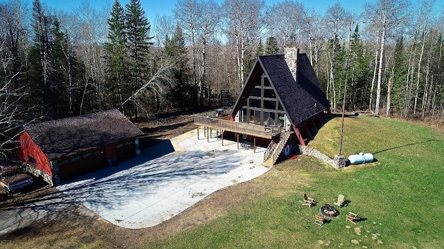 63521 County Road 2, Warroad, MN 56763 - view of front of home with a wooded view, a front lawn, a chimney, and a deck