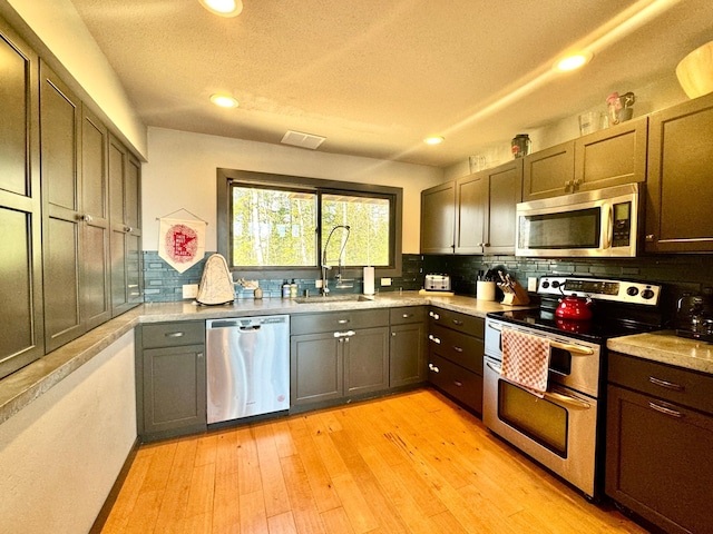63521 County Road 2, Warroad, MN 56763 - kitchen with a sink, light countertops, stainless steel appliances, recessed lighting, and decorative backsplash