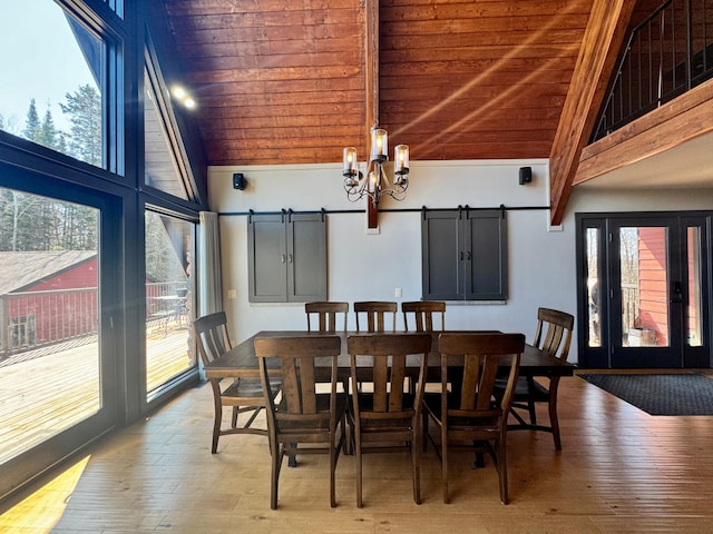 63521 County Road 2, Warroad, MN 56763 - dining space featuring a barn door, wood ceiling, a notable chandelier, and hardwood / wood-style floors