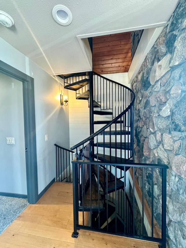 63521 County Road 2, Warroad, MN 56763 - staircase featuring a textured ceiling, baseboards, and wood finished floors