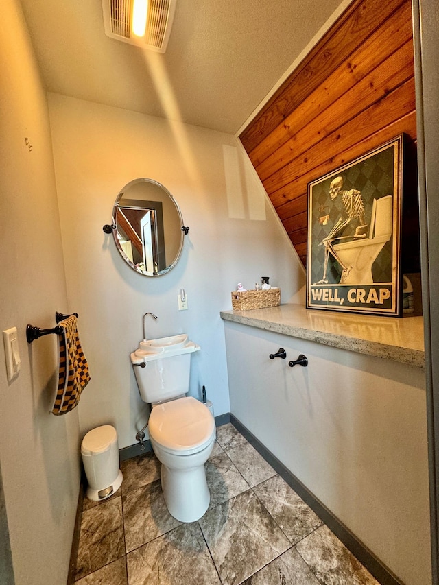 63521 County Road 2, Warroad, MN 56763 - bathroom with visible vents, baseboards, lofted ceiling, and toilet