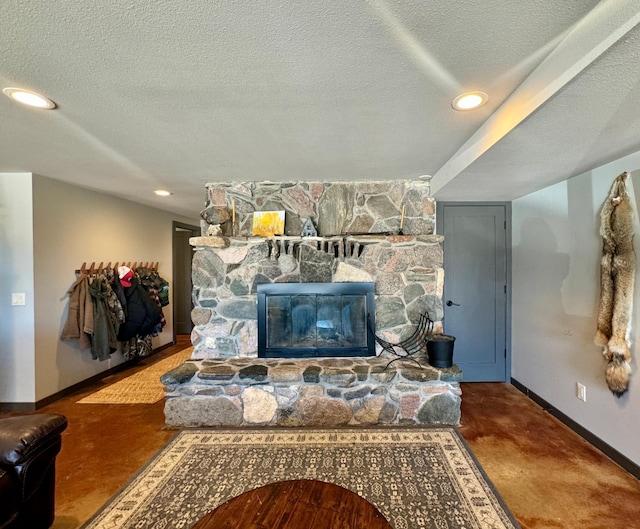 63521 County Road 2, Warroad, MN 56763 - living room with concrete flooring, a textured ceiling, a stone fireplace, recessed lighting, and baseboards