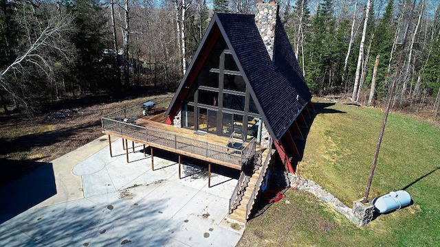 63521 County Road 2, Warroad, MN 56763 - rear view of property with a forest view, a chimney, a lawn, a deck, and stairway