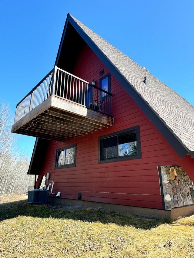 63521 County Road 2, Warroad, MN 56763 - view of side of home with a deck, cooling unit, and roof with shingles