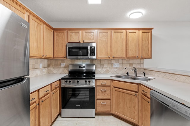 kitchen featuring a sink, light countertops, decorative backsplash, and stainless steel appliances