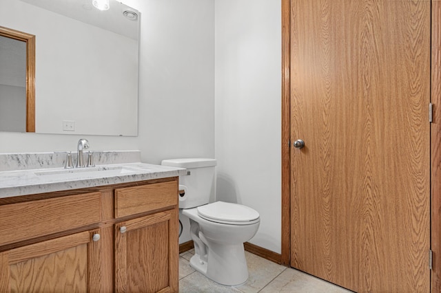 bathroom featuring vanity, baseboards, toilet, and tile patterned flooring