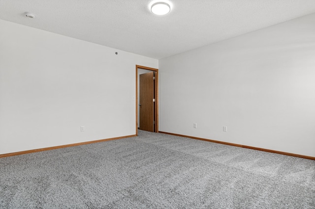 empty room featuring baseboards and carpet