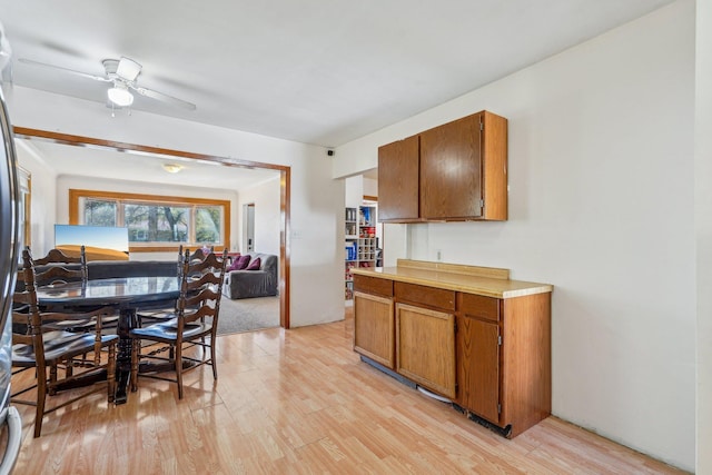 kitchen with light wood finished floors, brown cabinets, open floor plan, and light countertops