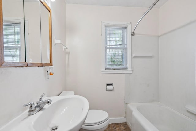 bathroom featuring a sink, baseboards, toilet, and tile patterned flooring