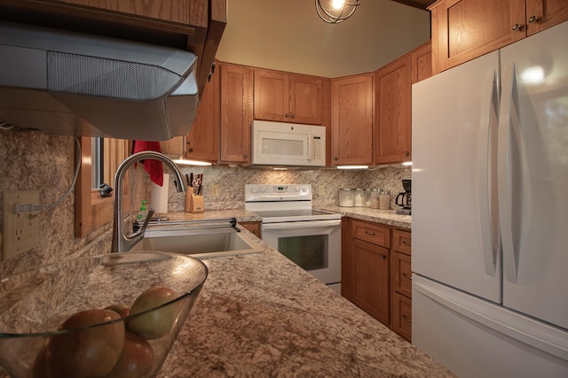 kitchen featuring white appliances, backsplash, brown cabinets, and a sink