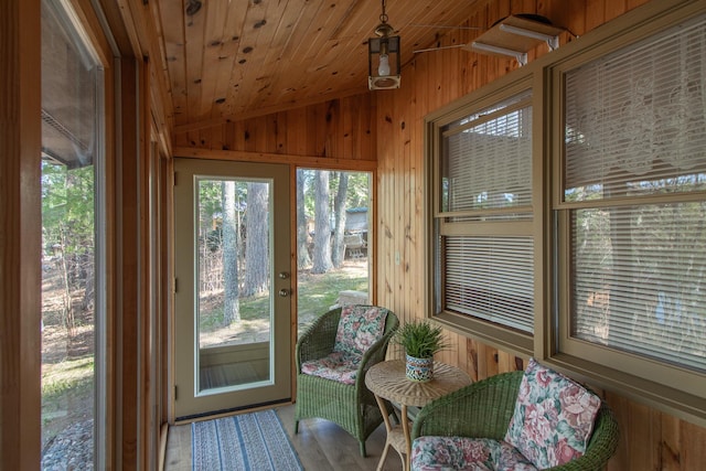 sunroom featuring vaulted ceiling, wood walls, and wood ceiling