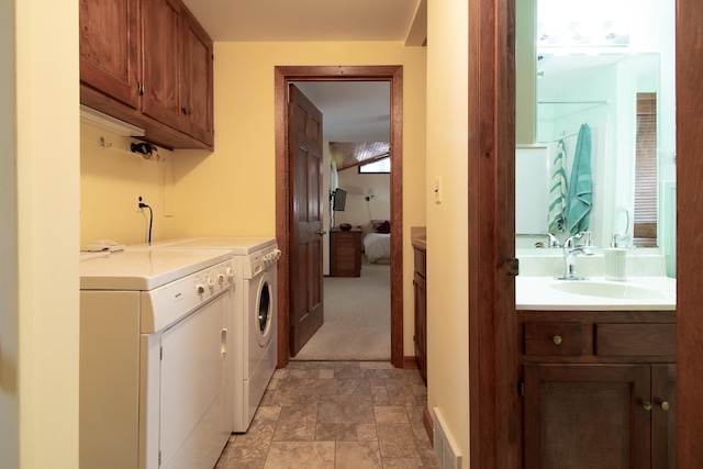 laundry room featuring a sink, washer and dryer, stone finish floors, and baseboards
