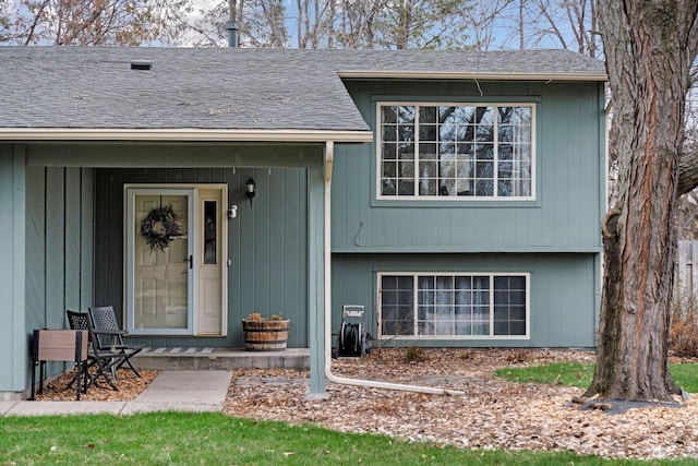 entrance to property featuring a shingled roof