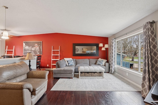 living area featuring baseboards, a textured ceiling, and dark wood finished floors