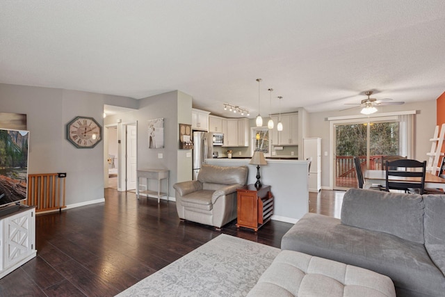 living room featuring baseboards, ceiling fan, and dark wood-type flooring