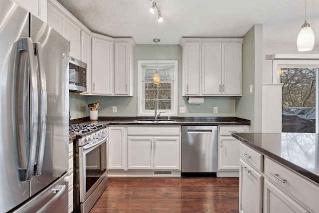 kitchen with visible vents, pendant lighting, a sink, white cabinets, and stainless steel appliances