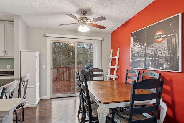 dining space with baseboards, ceiling fan, dark wood-style flooring, and a textured ceiling