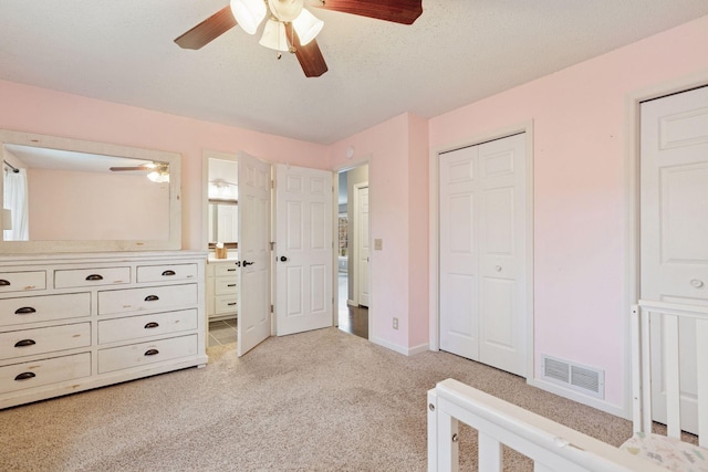 bedroom with connected bathroom, ceiling fan, light carpet, baseboards, and visible vents