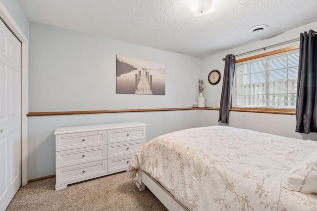 bedroom featuring a textured ceiling and light colored carpet