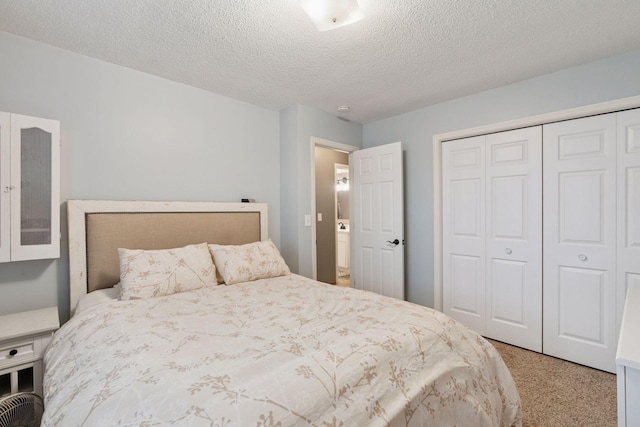 carpeted bedroom with a textured ceiling and a closet