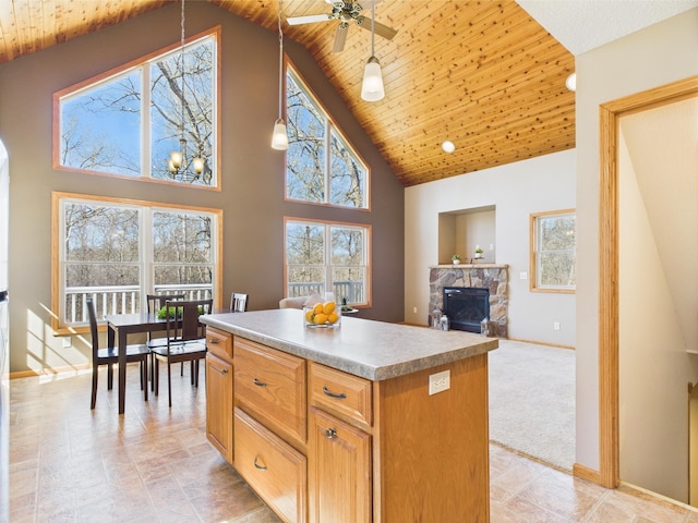 kitchen with a kitchen island, a ceiling fan, baseboards, and wood ceiling