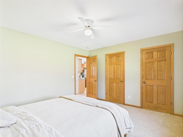 carpeted bedroom featuring baseboards and ceiling fan