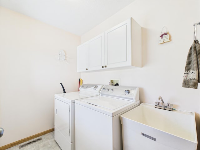 clothes washing area with washing machine and clothes dryer, cabinet space, a sink, baseboards, and visible vents
