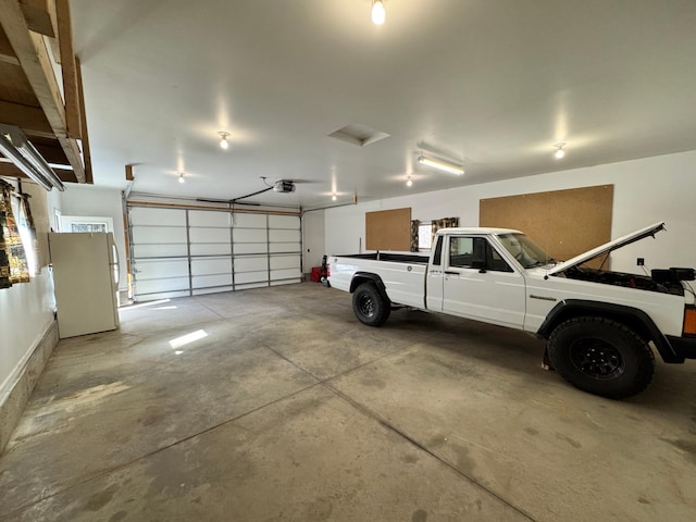 garage featuring a garage door opener and freestanding refrigerator