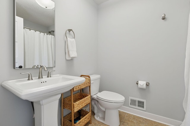 bathroom with visible vents, baseboards, tile patterned floors, and toilet