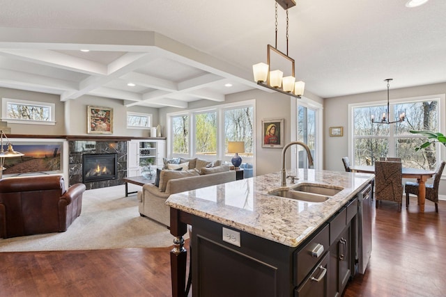kitchen featuring a chandelier, a healthy amount of sunlight, a sink, and dark wood-type flooring