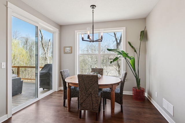dining space with a notable chandelier, visible vents, baseboards, and dark wood-type flooring
