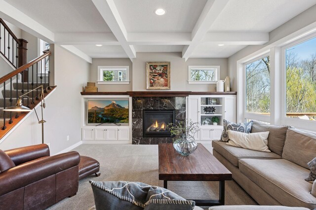 living area with a premium fireplace, stairs, recessed lighting, baseboards, and beamed ceiling