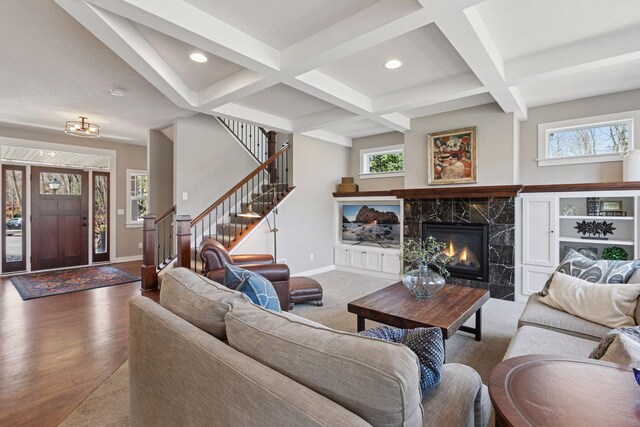 living area featuring beam ceiling, recessed lighting, baseboards, stairway, and coffered ceiling